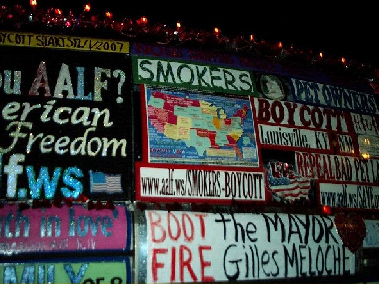 close up photograph of passenger side of smokers rights liberty van, words say smokers pet owners boycott, picture of smoking ban states map, boot the mayor, fire gilles meloche